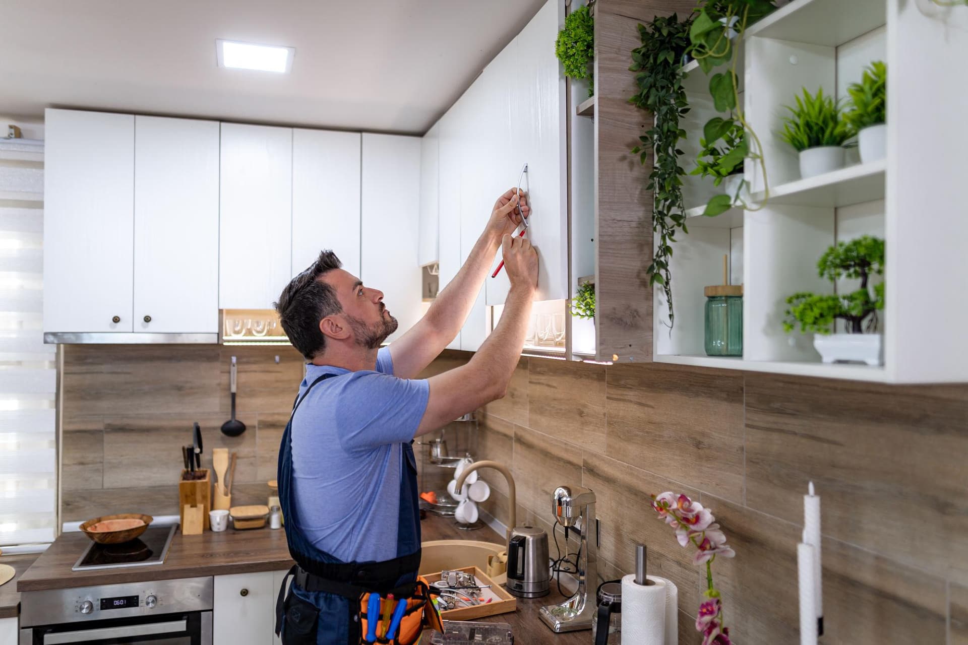 A carpenter installing kitchen cabinets
